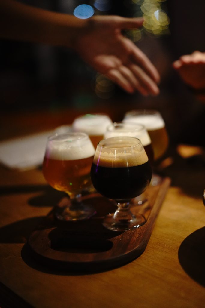 A flight of beers in small glasses sitting on a table at Hillgate Brewery.